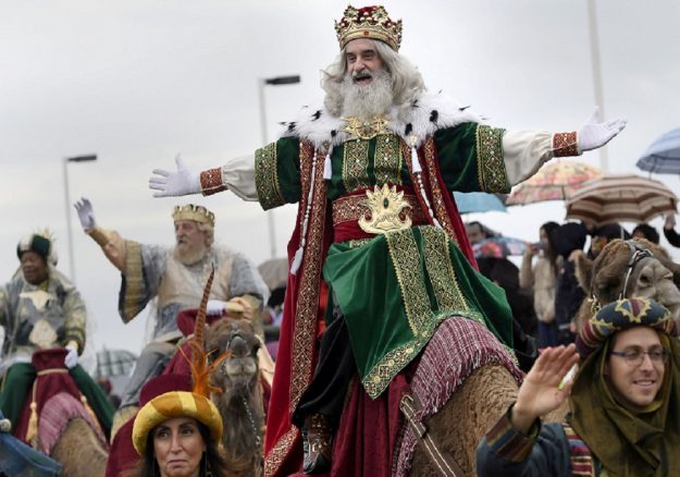 A man dressed as one of the Three Kings greets people during the Epiphany parade in Gijon